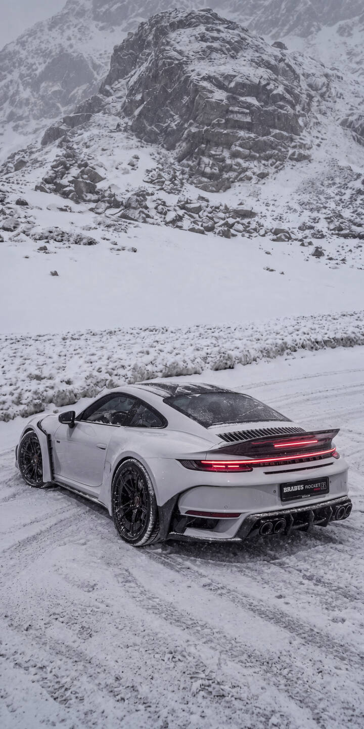 The sleek white Porsche, possibly a Brabus Rocket, glows with red taillights against the stark snowy mountain landscape in this breathtaking 4K wallpaper. This stunning automotive wallpaper is perfect for enhancing your iPhone screen with a blend of luxury and rugged beauty. | sports car snow winter iphone porsche mountains wallpaper mobile luxury car 4k wallpaper hd wallpaper brabus rocket The sleek white Porsche, possibly a Brabus Rocket, glows with red taillights against the stark snowy mountain landscape in this breathtaking 4K wallpaper. This stunning automotive wallpaper is perfect for enhancing your iPhone screen with a blend of luxury and rugged beauty.