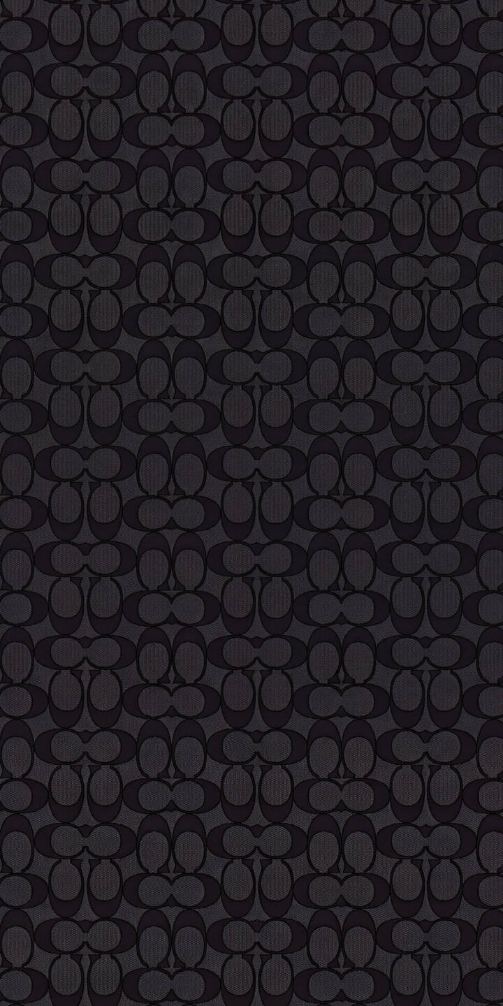 The iconic Coach C monogram repeats in a deep charcoal gray and black pattern across this elegant 4K wallpaper, featuring a subtle textured background that makes it a sophisticated mobile wallpaper for iPhone. | dark coach pattern iphone luxury wallpaper mobile 4k wallpaper hd wallpaper designer coach logo coach monogram The iconic Coach C monogram repeats in a deep charcoal gray and black pattern across this elegant 4K wallpaper, featuring a subtle textured background that makes it a sophisticated mobile wallpaper for iPhone.