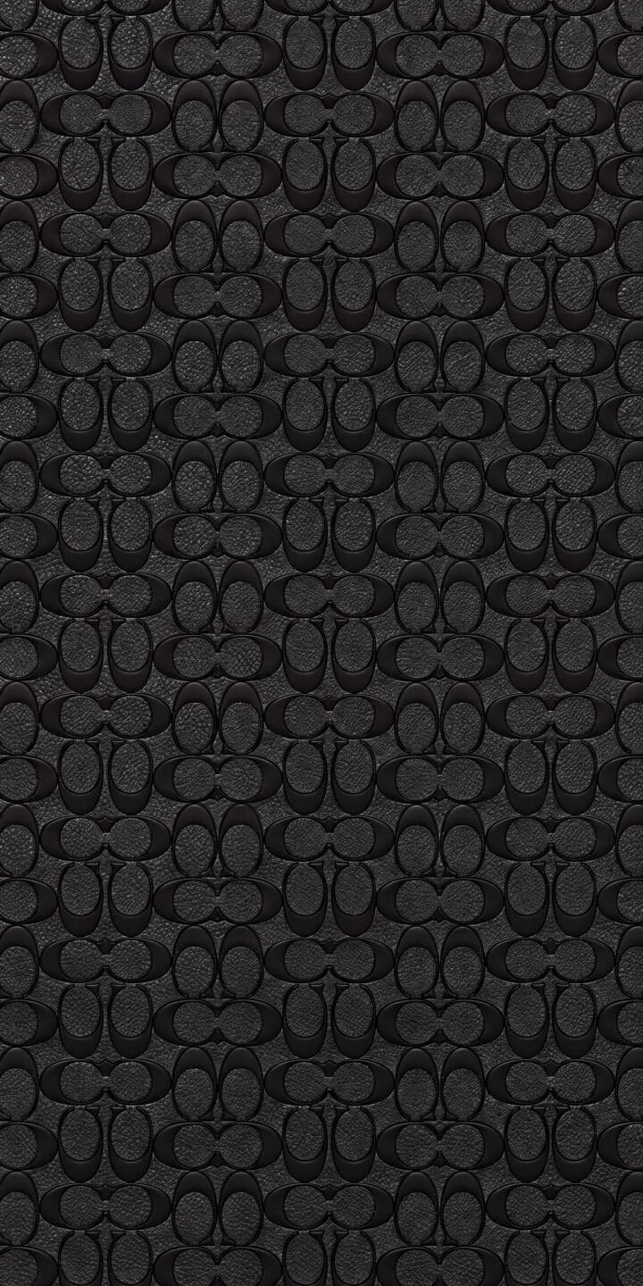 Embossed Coach C logos form a sophisticated repeating pattern on this elegant dark grey 4K wallpaper, featuring a luxurious textured finish. This minimalist design creates a refined aesthetic, perfect as an iPhone wallpaper for fans of the iconic brand. | coach pattern iphone minimalist wallpaper fashion texture mobile 4k wallpaper hd wallpaper luxury brand coach logo Embossed Coach C logos form a sophisticated repeating pattern on this elegant dark grey 4K wallpaper, featuring a luxurious textured finish. This minimalist design creates a refined aesthetic, perfect as an iPhone wallpaper for fans of the iconic brand.