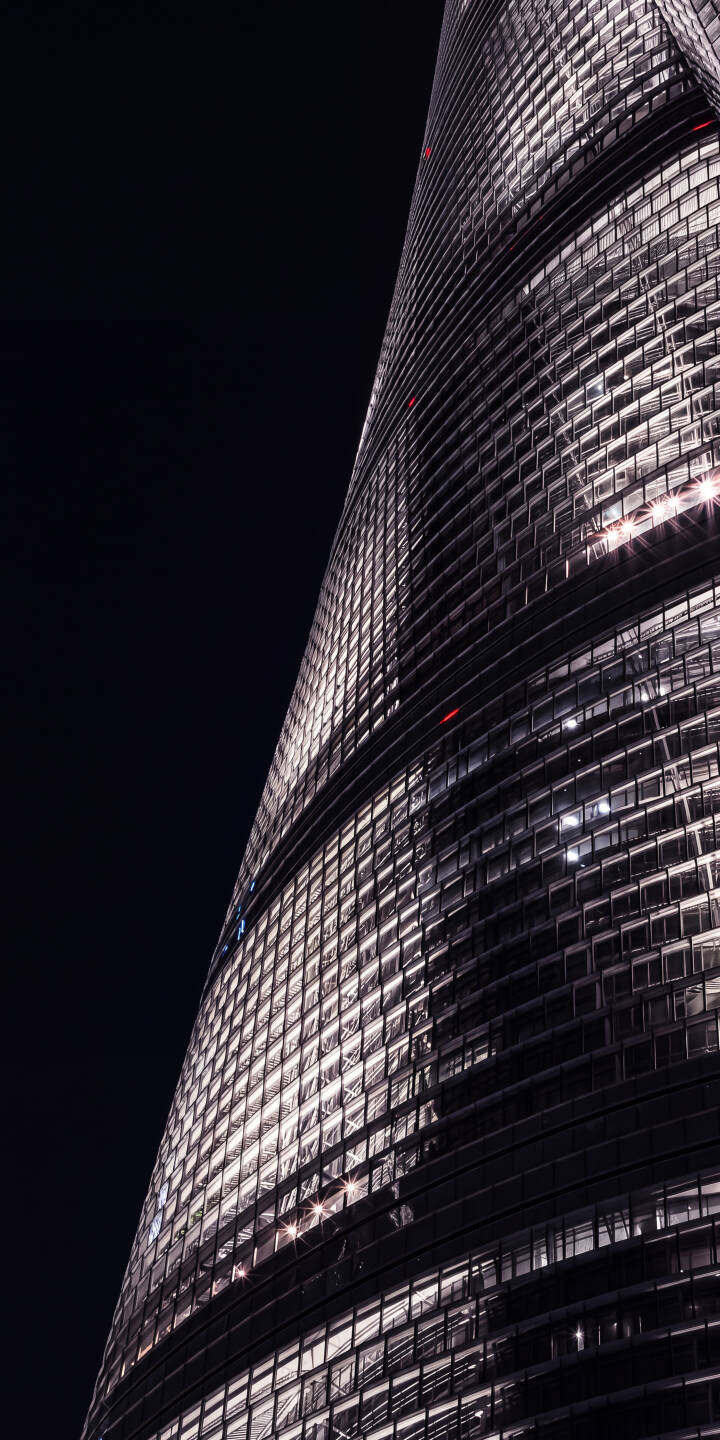Glistening windows illuminate the dark night sky, revealing the sleek, curving facade of a modern skyscraper in this breathtaking 4K wallpaper. This stunning architectural wallpaper is perfect for any iPhone, adding a touch of urban sophistication. | urban dark night skyscraper architecture iphone wallpaper futuristic mobile 4k wallpaper hd wallpaper Glistening windows illuminate the dark night sky, revealing the sleek, curving facade of a modern skyscraper in this breathtaking 4K wallpaper. This stunning architectural wallpaper is perfect for any iPhone, adding a touch of urban sophistication.