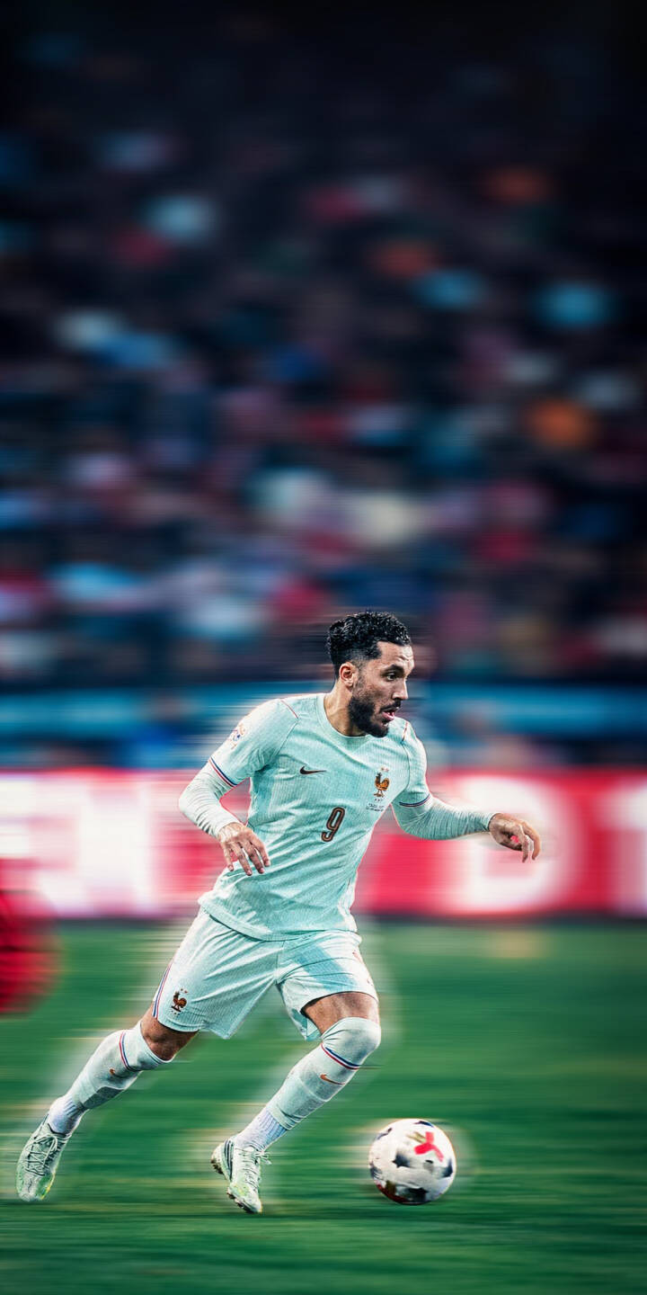 The focused French footballer, adorned in a light blue kit, charges forward with a determined gaze, skillfully dribbling the ball across a vibrant green pitch. This dynamic action shot makes a perfect 4K wallpaper for iPhone, offering an energetic sports wallpaper experience. | sports football athletic iphone soccer wallpaper action mobile 4k wallpaper hd wallpaper dribbling cherki french player The focused French footballer, adorned in a light blue kit, charges forward with a determined gaze, skillfully dribbling the ball across a vibrant green pitch. This dynamic action shot makes a perfect 4K wallpaper for iPhone, offering an energetic sports wallpaper experience.