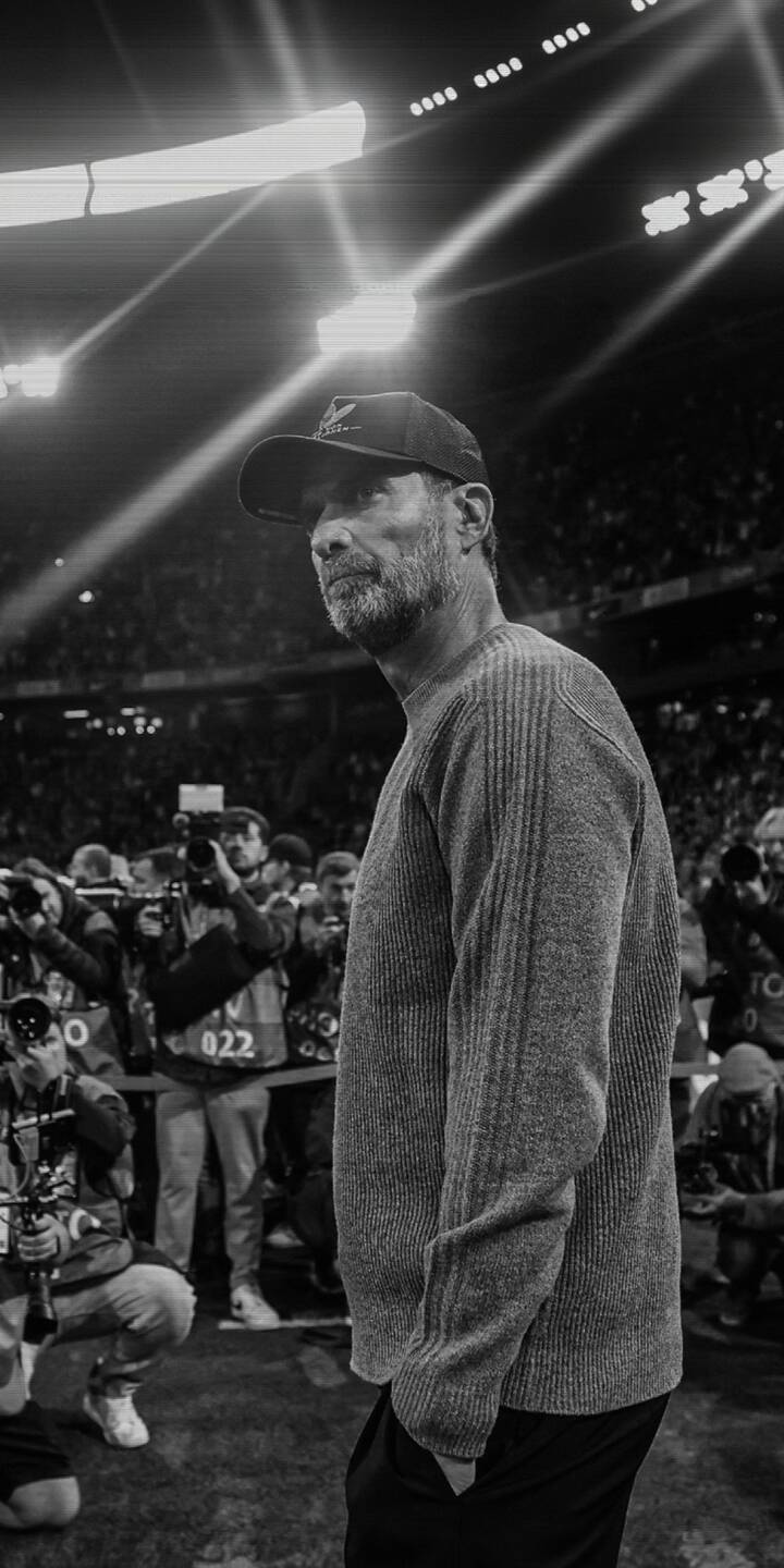 Bathed in monochrome stadium lights, Jürgen Klopp appears pensive and focused, his signature beard and cap prominent in this striking 4K wallpaper. This powerful grayscale image, featuring the esteemed coach among blurred photographers, makes an exceptional iPhone wallpaper for fans. | sports stadium iphone soccer wallpaper grayscale mobile 4k wallpaper hd wallpaper manager klopp jürgen klopp Bathed in monochrome stadium lights, Jürgen Klopp appears pensive and focused, his signature beard and cap prominent in this striking 4K wallpaper. This powerful grayscale image, featuring the esteemed coach among blurred photographers, makes an exceptional iPhone wallpaper for fans.