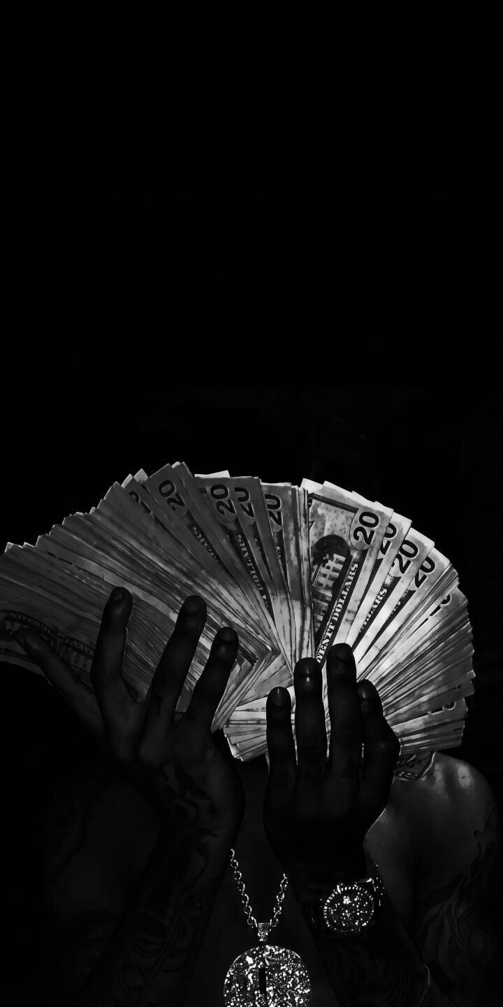 Crisply fanned twenty-dollar bills shine under direct light, held by dark hands wearing striking jewelry against a deep black background in this stunning 4K wallpaper. This monochrome money wallpaper makes an opulent statement for your iPhone. | dark cash money bills iphone luxury wallpaper mobile 4k wallpaper hd wallpaper monochrome wealth Crisply fanned twenty-dollar bills shine under direct light, held by dark hands wearing striking jewelry against a deep black background in this stunning 4K wallpaper. This monochrome money wallpaper makes an opulent statement for your iPhone.