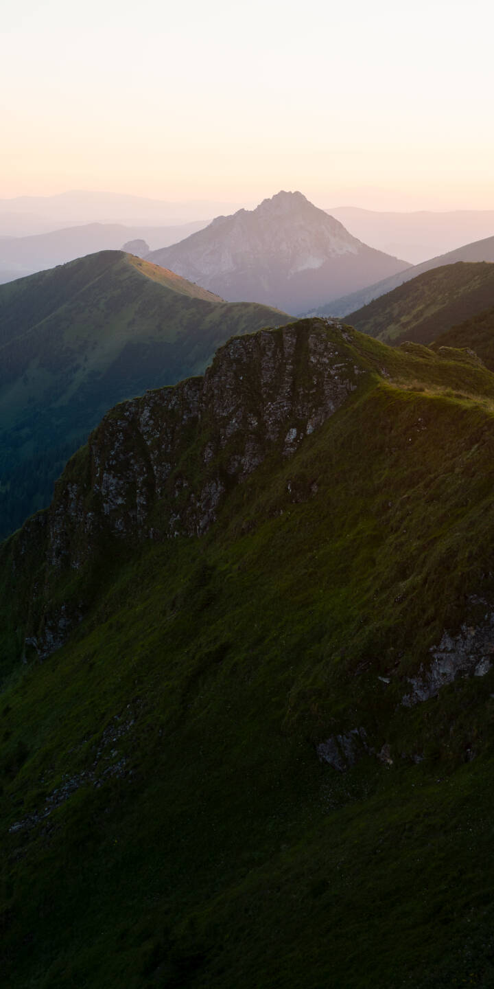 A breathtaking blend of soft pink and gold illuminates distant, misty mountain peaks, creating a serene layered landscape in this stunning 4K wallpaper. The rugged foreground ridge, adorned with lush green grass, makes this an epic nature wallpaper perfect for your iPhone. | nature hills mountains slovakia A breathtaking blend of soft pink and gold illuminates distant, misty mountain peaks, creating a serene layered landscape in this stunning 4K wallpaper. The rugged foreground ridge, adorned with lush green grass, makes this an epic nature wallpaper perfect for your iPhone.