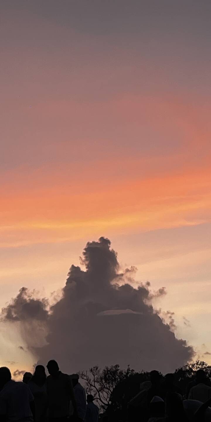 sunset sky filled with warm orange, pink, and purple gradients, contrasted by dramatic cloud formations and silhouetted onlookers | sky cloud nature vibe sunset sky filled with warm orange, pink, and purple gradients, contrasted by dramatic cloud formations and silhouetted onlookers