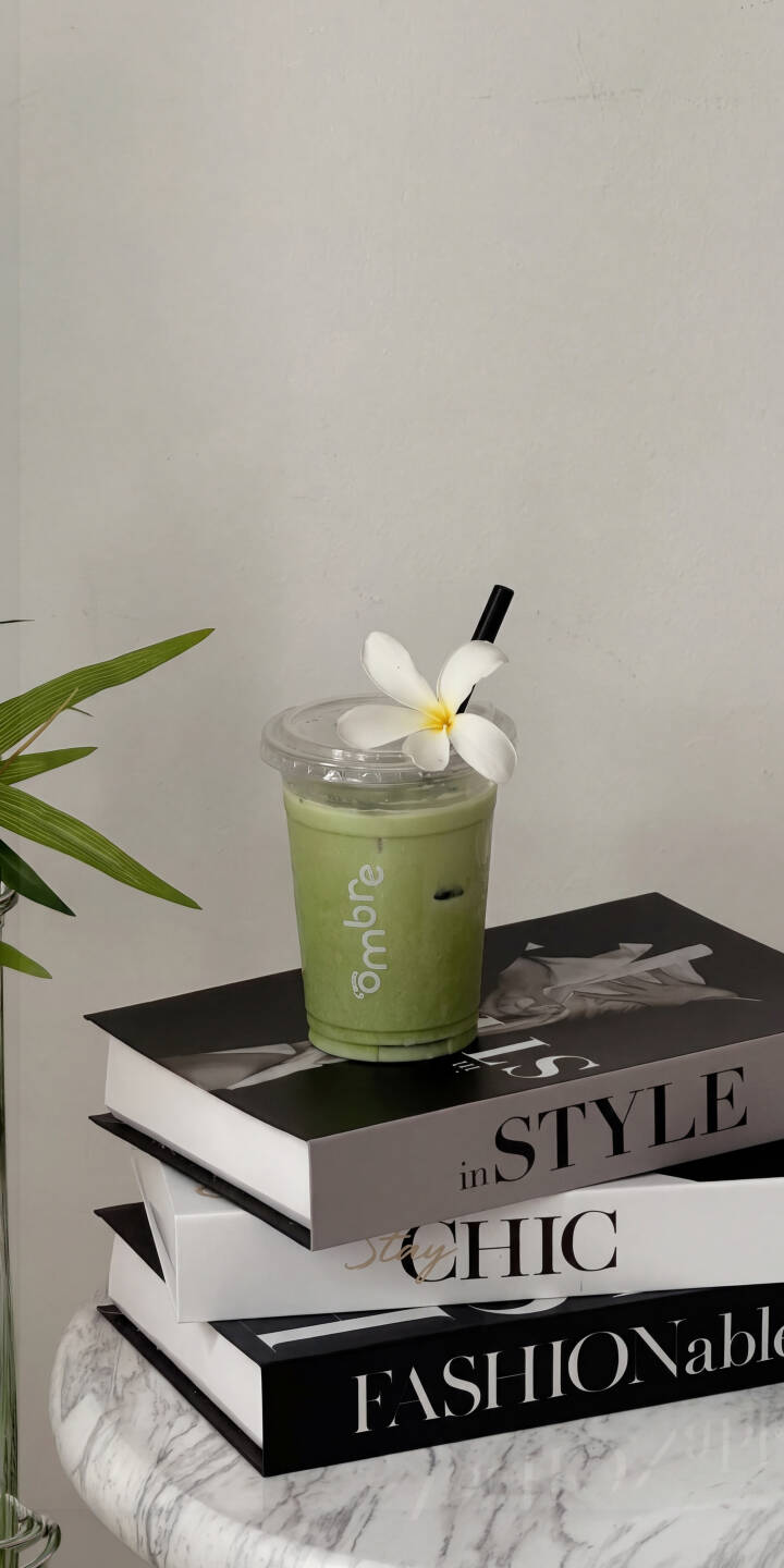 A delicate white plumeria flower adorns a vibrant green matcha latte, perched atop a stack of chic fashion books, creating a serene 4K wallpaper perfect for iPhone. This stylish and calm wallpaper captures an inviting café aesthetic for your screen. | aesthetic drink iphone minimalist wallpaper mobile matcha 4k wallpaper hd wallpaper cafe green tea plumeria A delicate white plumeria flower adorns a vibrant green matcha latte, perched atop a stack of chic fashion books, creating a serene 4K wallpaper perfect for iPhone. This stylish and calm wallpaper captures an inviting café aesthetic for your screen.