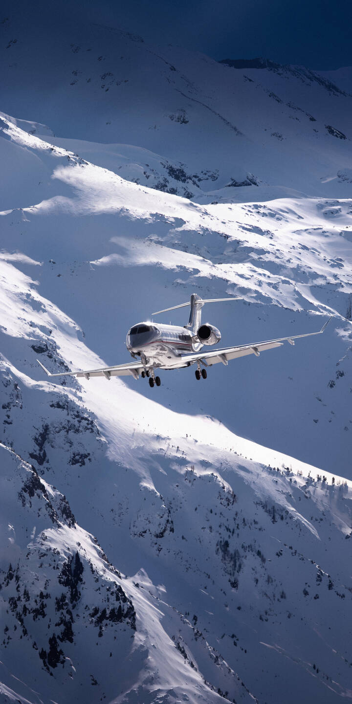 A sleek silver private jet descends over majestic snow-capped mountains, its landing gear extended against the vibrant blue sky in this stunning 4K wallpaper. This premium wallpaper provides a luxurious, high-altitude view perfect for any iPhone. | winter iphone private jet luxury airplane wallpaper mobile 4k wallpaper hd wallpaper aerial snow mountains business jet A sleek silver private jet descends over majestic snow-capped mountains, its landing gear extended against the vibrant blue sky in this stunning 4K wallpaper. This premium wallpaper provides a luxurious, high-altitude view perfect for any iPhone.