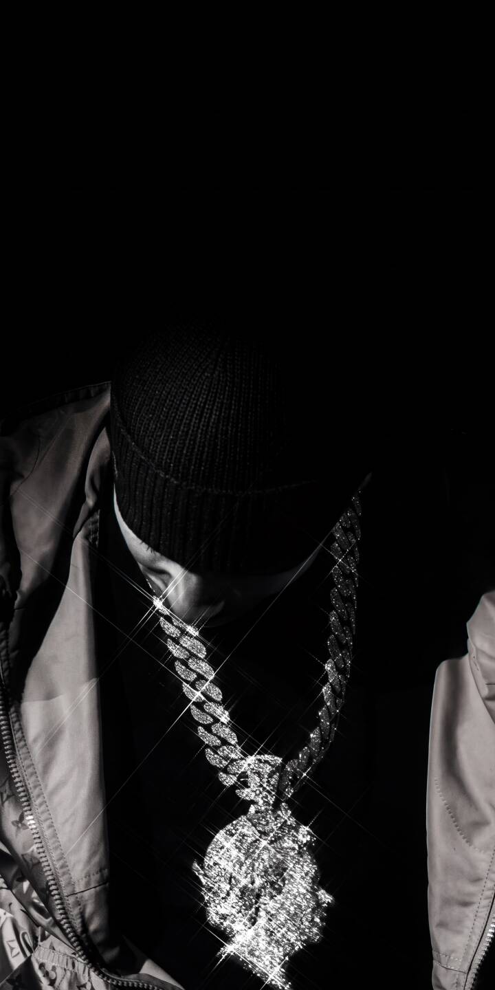 The incredible sparkle of an oversized diamond chain dominates this striking 4K grayscale wallpaper, highlighting a figure wearing a dark beanie and a dazzling head-shaped pendant — a luxurious wallpaper perfect for iPhone. | aesthetic dark pendant iphone luxury wallpaper grayscale mobile 4k wallpaper hd wallpaper diamond chain bling The incredible sparkle of an oversized diamond chain dominates this striking 4K grayscale wallpaper, highlighting a figure wearing a dark beanie and a dazzling head-shaped pendant — a luxurious wallpaper perfect for iPhone.