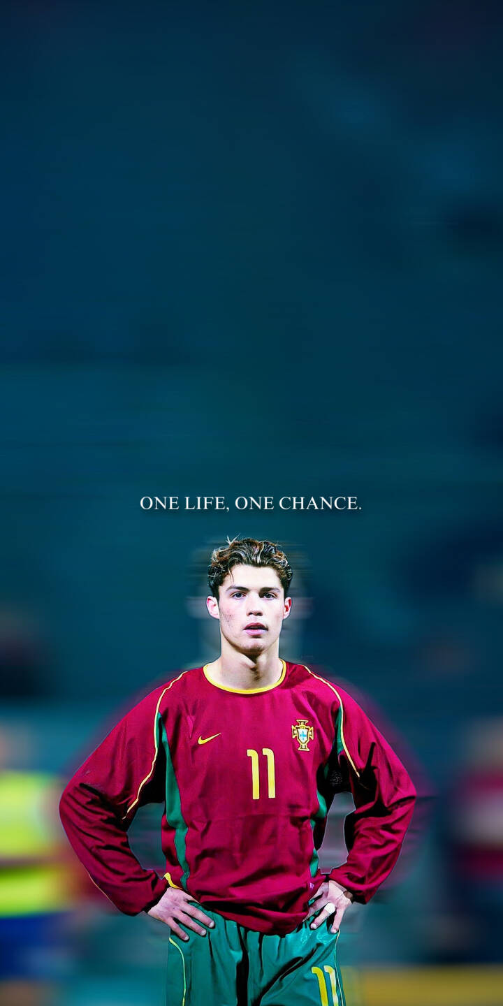 A young Cristiano Ronaldo, hands on hips with a focused expression and the inspiring text 'ONE LIFE, ONE CHANCE.' above him, graces this striking 4K wallpaper. This iconic Portugal kit moment creates a powerful mobile wallpaper for iPhone fans. | football athlete iphone soccer wallpaper cr7 portugal cristiano ronaldo mobile 4k wallpaper hd wallpaper inspirational A young Cristiano Ronaldo, hands on hips with a focused expression and the inspiring text 'ONE LIFE, ONE CHANCE.' above him, graces this striking 4K wallpaper. This iconic Portugal kit moment creates a powerful mobile wallpaper for iPhone fans.