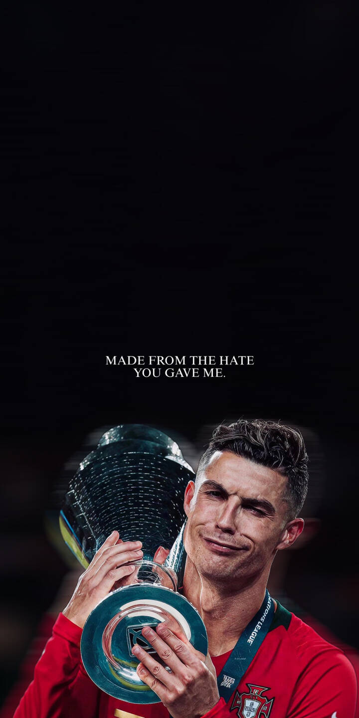 Cristiano Ronaldo wears a defiant smirk as he proudly hoists a gleaming silver trophy, set against a dark backdrop with the powerful text 'MADE FROM THE HATE YOU GAVE ME.'. This motivational 4K wallpaper makes a compelling statement and is a perfect wallpaper for your iPhone. | football trophy motivational iphone ronaldo wallpaper cr7 cristiano ronaldo mobile 4k wallpaper hd wallpaper dark background Cristiano Ronaldo wears a defiant smirk as he proudly hoists a gleaming silver trophy, set against a dark backdrop with the powerful text 'MADE FROM THE HATE YOU GAVE ME.'. This motivational 4K wallpaper makes a compelling statement and is a perfect wallpaper for your iPhone.