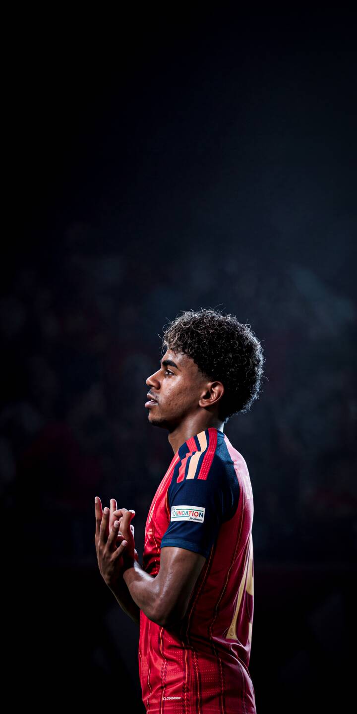 The subtle glow of stadium lights frames Gavi's focused profile as his hands are clasped in a moment of reflection in this striking 4K wallpaper. Perfect for your iPhone, this wallpaper captures the young midfielder in his iconic red and navy kit. | athletic portrait iphone soccer spain wallpaper mobile footballer 4k wallpaper hd wallpaper gavi pensive The subtle glow of stadium lights frames Gavi's focused profile as his hands are clasped in a moment of reflection in this striking 4K wallpaper. Perfect for your iPhone, this wallpaper captures the young midfielder in his iconic red and navy kit.