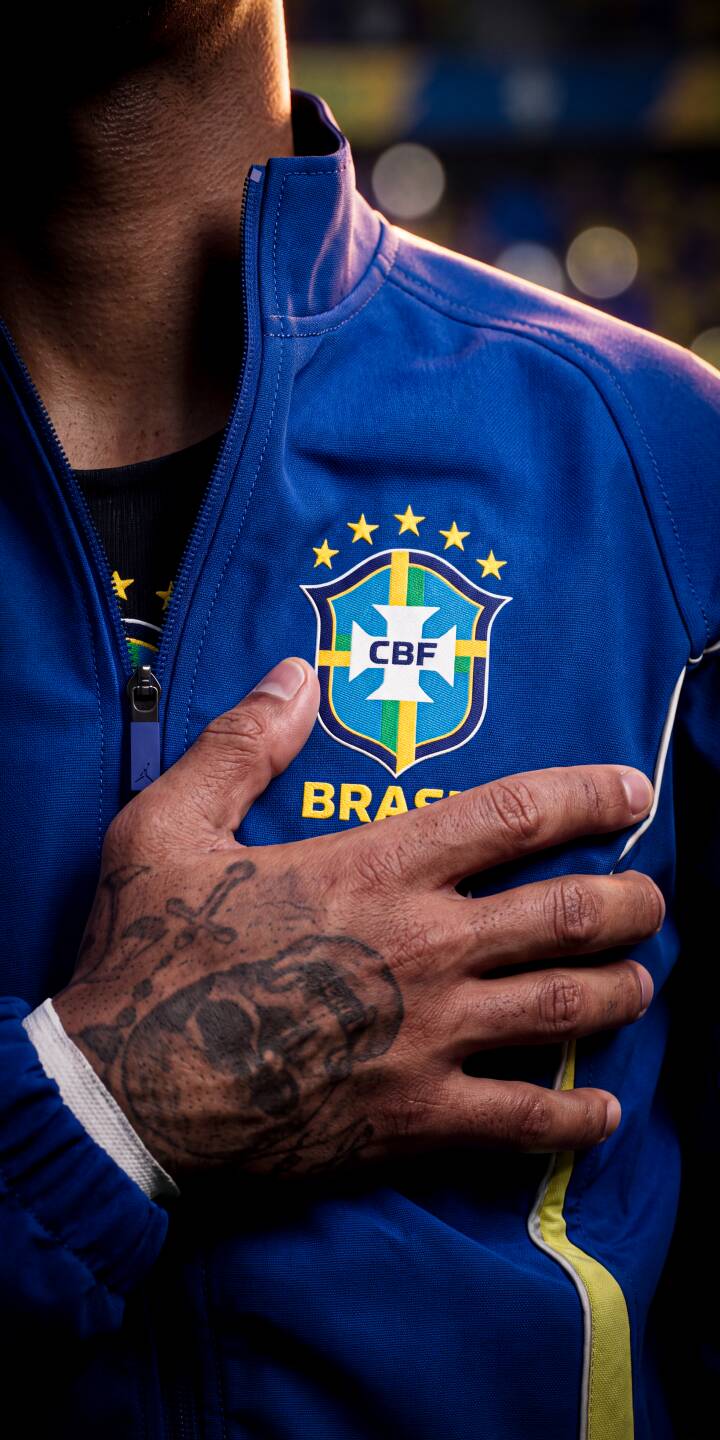 Dramatic light highlights the iconic CBF crest on a vibrant blue Brazil jacket, with a tattooed hand placed reverently over the chest in this compelling 4K wallpaper an essential iPhone wallpaper for any true football fan. | football tattoo iphone wallpaper brazil sport mobile 4k wallpaper hd wallpaper blue jersey patriotism cbf Dramatic light highlights the iconic CBF crest on a vibrant blue Brazil jacket, with a tattooed hand placed reverently over the chest in this compelling 4K wallpaper an essential iPhone wallpaper for any true football fan.