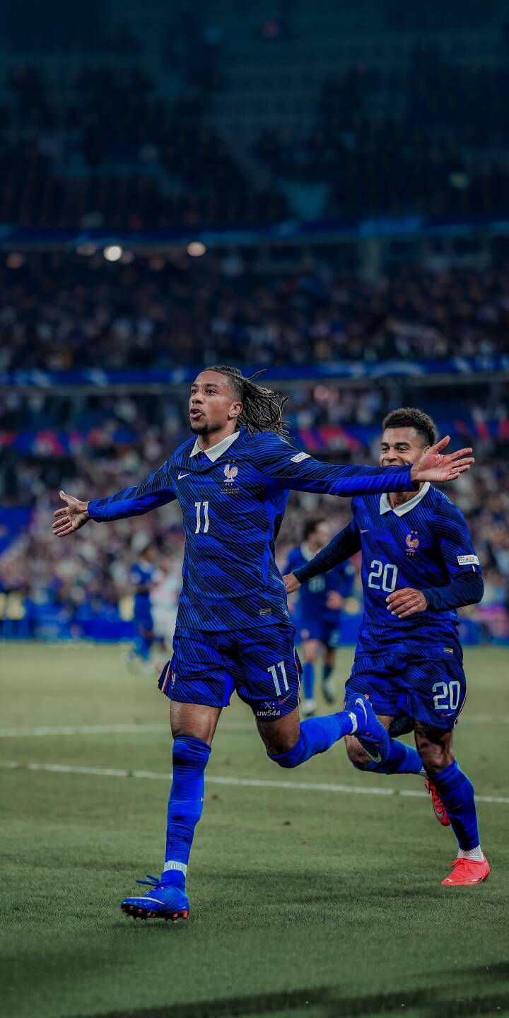 Ecstatic Christopher Nkunku, with his distinctive dreadlocks and arms wide, celebrates a monumental goal in his vibrant blue French kit in this electrifying 4K wallpaper. This dynamic football wallpaper is a must-have for iPhone users to showcase their passion for the game. | sports celebration iphone wallpaper mobile 4k wallpaper hd wallpaper blue kit france football christopher nkunku nkunku football pitch Ecstatic Christopher Nkunku, with his distinctive dreadlocks and arms wide, celebrates a monumental goal in his vibrant blue French kit in this electrifying 4K wallpaper. This dynamic football wallpaper is a must-have for iPhone users to showcase their passion for the game.