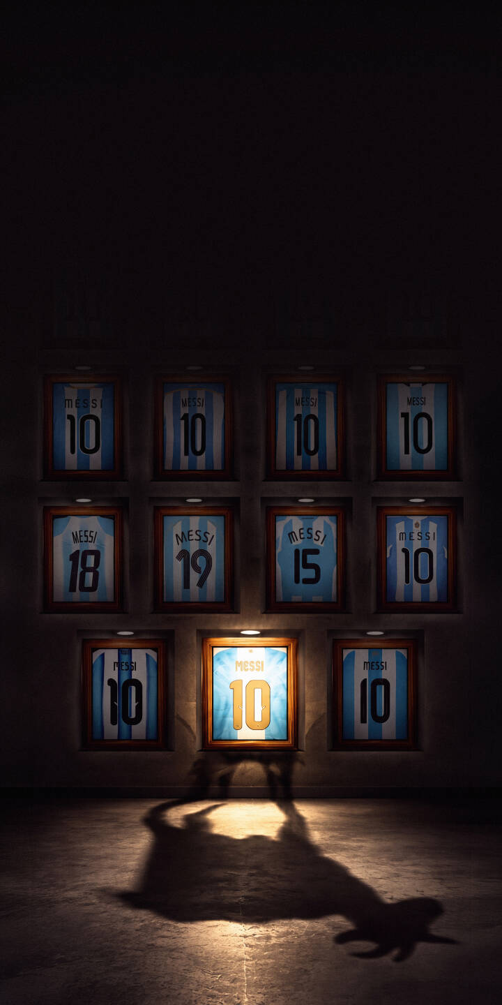 A dramatic shadow of Lionel Messi hoisting the World Cup trophy extends across a concrete floor, cast from a brightly lit, framed number 10 Argentina jersey. This powerful 4K wallpaper for iPhone is a must-have wallpaper for any true football fan. | football shadow iphone messi argentina wallpaper lionel messi mobile 4k wallpaper hd wallpaper world cup A dramatic shadow of Lionel Messi hoisting the World Cup trophy extends across a concrete floor, cast from a brightly lit, framed number 10 Argentina jersey. This powerful 4K wallpaper for iPhone is a must-have wallpaper for any true football fan.