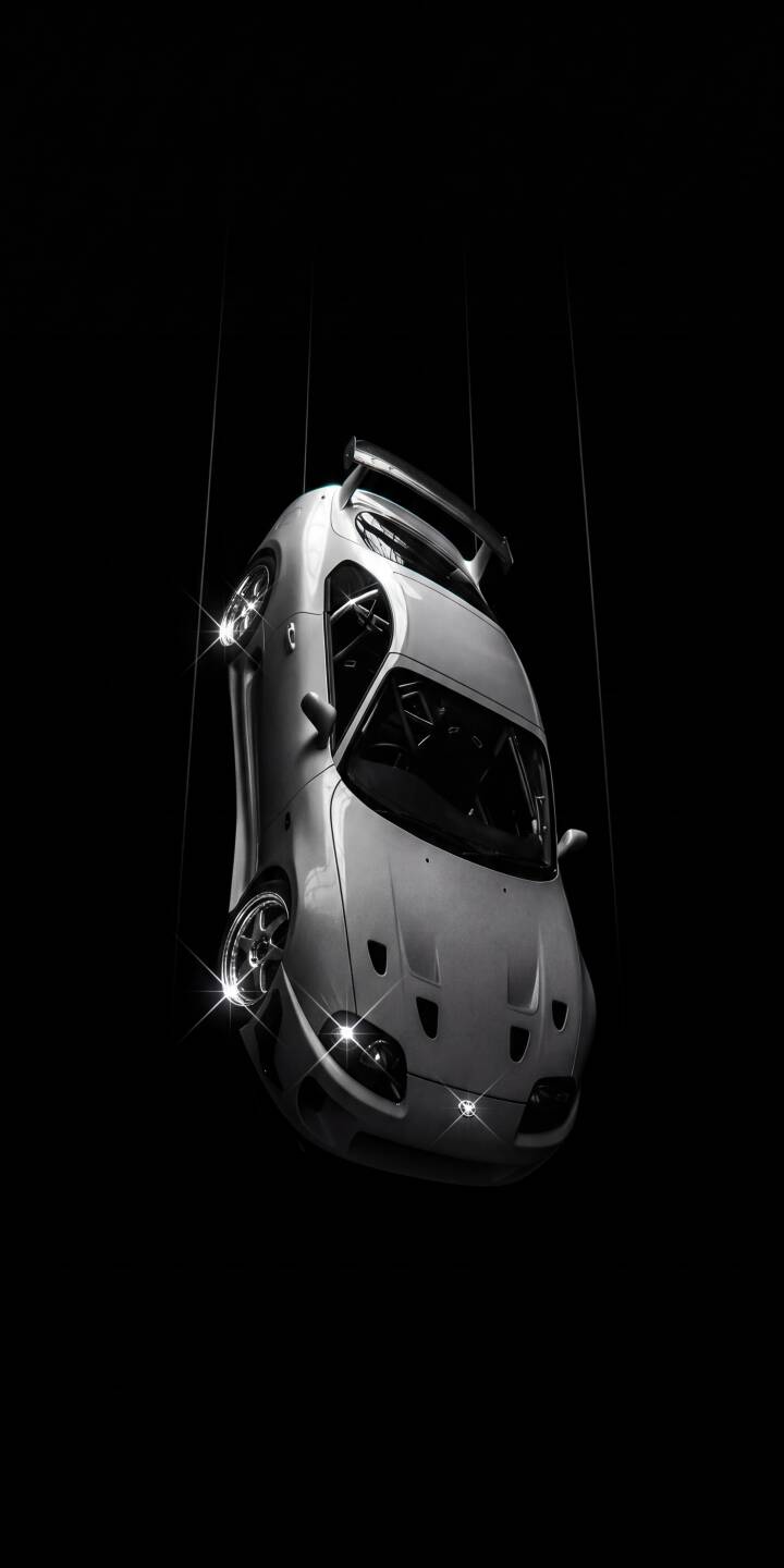 A stark white Toyota Supra appears suspended mid-air, its sleek contours gleaming against an intense black backdrop with brilliant highlights reflecting off its wheels and headlights in this stunning 4K wallpaper. This captivating minimalist car wallpaper is perfect for personalizing your iPhone. | dark iphone supra minimalist wallpaper toyota supra sportscar mobile 4k wallpaper hd wallpaper automotive jdm A stark white Toyota Supra appears suspended mid-air, its sleek contours gleaming against an intense black backdrop with brilliant highlights reflecting off its wheels and headlights in this stunning 4K wallpaper. This captivating minimalist car wallpaper is perfect for personalizing your iPhone.