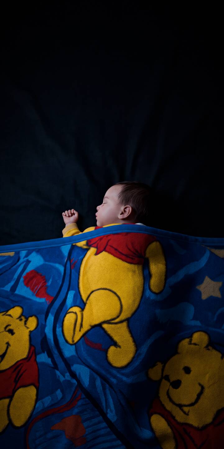 A serene baby sleeps peacefully, bundled in a vibrant blue Winnie the Pooh blanket, in this heartwarming 4K wallpaper - a perfect cozy wallpaper for iPhone users. | disney baby cute iphone winnie the pooh cozy wallpaper mobile 4k wallpaper hd wallpaper pooh bear sleeping baby A serene baby sleeps peacefully, bundled in a vibrant blue Winnie the Pooh blanket, in this heartwarming 4K wallpaper - a perfect cozy wallpaper for iPhone users.