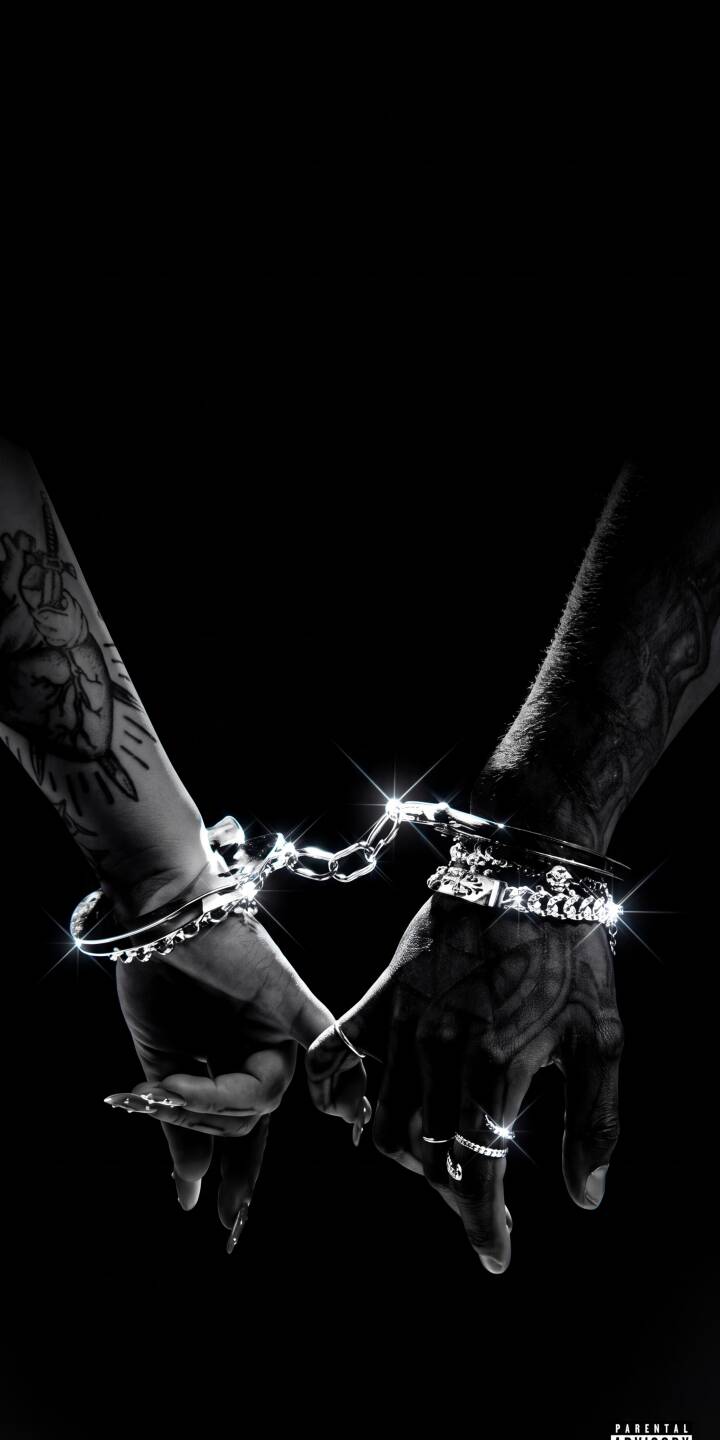 Glittering silver handcuffs brilliantly connect two intricately tattooed arms, forming a subtle heart shape against the deep black background in this powerful 4K wallpaper. This stunning wallpaper for iPhone is perfect for showcasing a strong, intimate bond. | aesthetic dark iphone hands wallpaper black and white sparkling mobile 4k wallpaper hd wallpaper tattoos handcuffs Glittering silver handcuffs brilliantly connect two intricately tattooed arms, forming a subtle heart shape against the deep black background in this powerful 4K wallpaper. This stunning wallpaper for iPhone is perfect for showcasing a strong, intimate bond.
