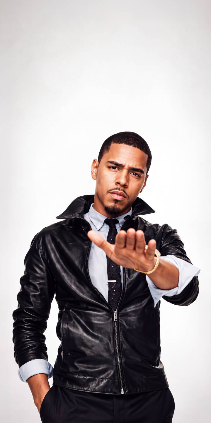 J. Cole extends his hand in a confident 'stop' gesture, dressed in a sleek black leather jacket and tie, making for an iconic 4K wallpaper perfect for iPhone fans. | rapper pose leather jacket iphone stylish wallpaper hip hop mobile 4k wallpaper hd wallpaper musician j.cole J. Cole extends his hand in a confident 'stop' gesture, dressed in a sleek black leather jacket and tie, making for an iconic 4K wallpaper perfect for iPhone fans.