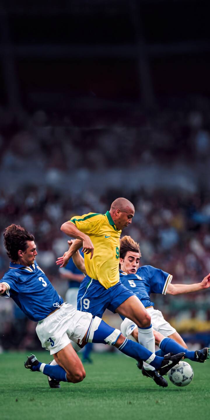 In a dynamic display of skill, Ronaldo Nazário in his iconic yellow Brazil #9 jersey expertly navigates past two diving Italian defenders, creating an unforgettable 4K football wallpaper for iPhone. This legendary moment of dribbling mastery makes an epic retro sports wallpaper for any fan. | football iphone retro ronaldo soccer wallpaper mobile 4k wallpaper hd wallpaper brasil iconic ronaldo nazario In a dynamic display of skill, Ronaldo Nazário in his iconic yellow Brazil #9 jersey expertly navigates past two diving Italian defenders, creating an unforgettable 4K football wallpaper for iPhone. This legendary moment of dribbling mastery makes an epic retro sports wallpaper for any fan.