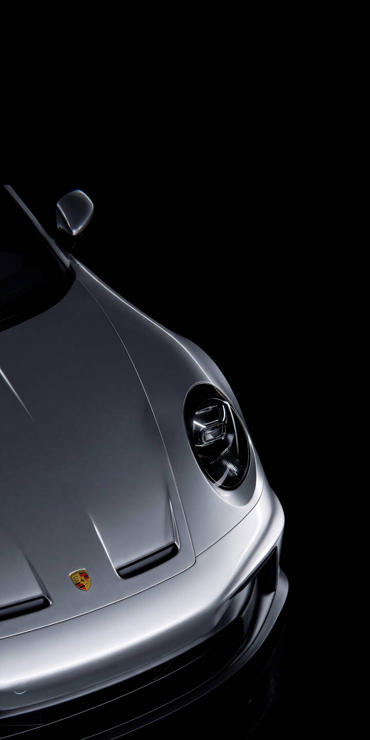 The gleaming silver body of a Porsche 911 dramatically emerges from a dark background in this stunning 4K wallpaper, highlighting its iconic emblem and intense headlight — an essential wallpaper for any iPhone car enthusiast. | sports car iphone porsche wallpaper mobile luxury car porsche 911 4k wallpaper hd wallpaper automotive sleek dark aesthetic The gleaming silver body of a Porsche 911 dramatically emerges from a dark background in this stunning 4K wallpaper, highlighting its iconic emblem and intense headlight — an essential wallpaper for any iPhone car enthusiast.