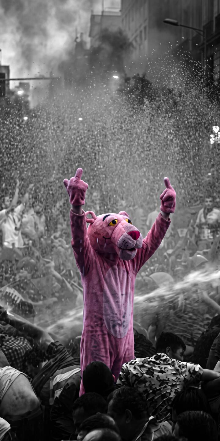 The vibrant pink Pink Panther costume vividly pops against the grayscale, chaotic protest crowd as the character defiantly flips both middle fingers in this striking 4K wallpaper. This powerful wallpaper is a must-have for iPhone users seeking a unique and rebellious statement. | street art iphone wallpaper pink panther mobile 4k wallpaper hd wallpaper protest pop culture selective color defiance pinkpanther The vibrant pink Pink Panther costume vividly pops against the grayscale, chaotic protest crowd as the character defiantly flips both middle fingers in this striking 4K wallpaper. This powerful wallpaper is a must-have for iPhone users seeking a unique and rebellious statement.