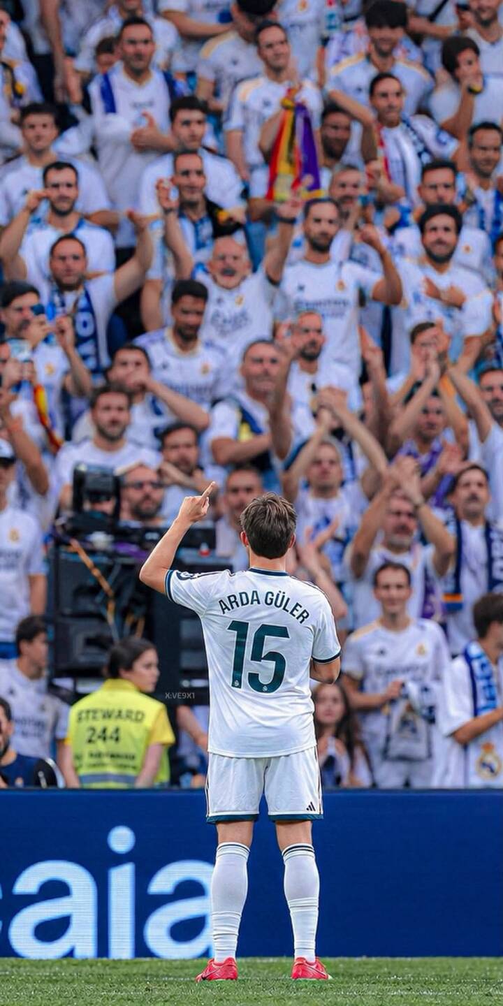 Arda Güler gestures towards the ecstatic crowd, acknowledging their cheers in this dynamic 4K football wallpaper. This inspiring moment of connection with the fans makes a striking wallpaper for your iPhone. | football stadium player iphone soccer fans real madrid wallpaper mobile arda güler 4k wallpaper hd wallpaper Arda Güler gestures towards the ecstatic crowd, acknowledging their cheers in this dynamic 4K football wallpaper. This inspiring moment of connection with the fans makes a striking wallpaper for your iPhone.