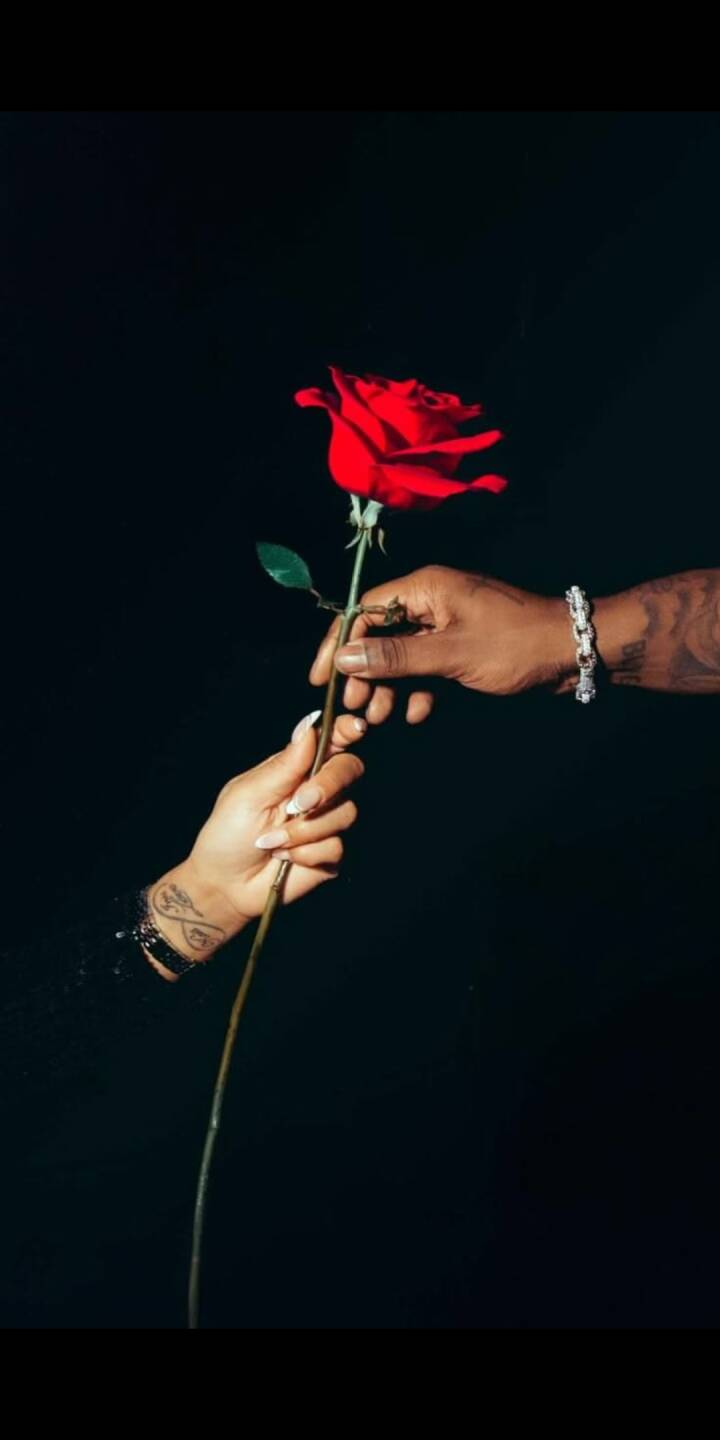 A vibrant red rose is delicately passed between two hands against a deep black background in this intimate 4K wallpaper. This romantic image, featuring a glistening bracelet and elegant manicured nails, makes a perfect aesthetic wallpaper for your iPhone. | flower A vibrant red rose is delicately passed between two hands against a deep black background in this intimate 4K wallpaper. This romantic image, featuring a glistening bracelet and elegant manicured nails, makes a perfect aesthetic wallpaper for your iPhone.