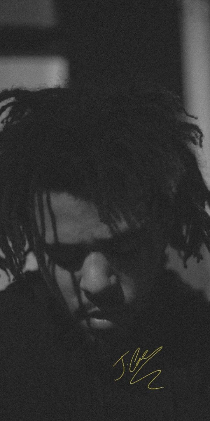 A poignant play of shadow and light defines this monochromatic 4K J. Cole wallpaper, highlighting his contemplative pose against a subtle background, completed by a striking yellow signature — an essential wallpaper for any iPhone. | artist A poignant play of shadow and light defines this monochromatic 4K J. Cole wallpaper, highlighting his contemplative pose against a subtle background, completed by a striking yellow signature — an essential wallpaper for any iPhone.