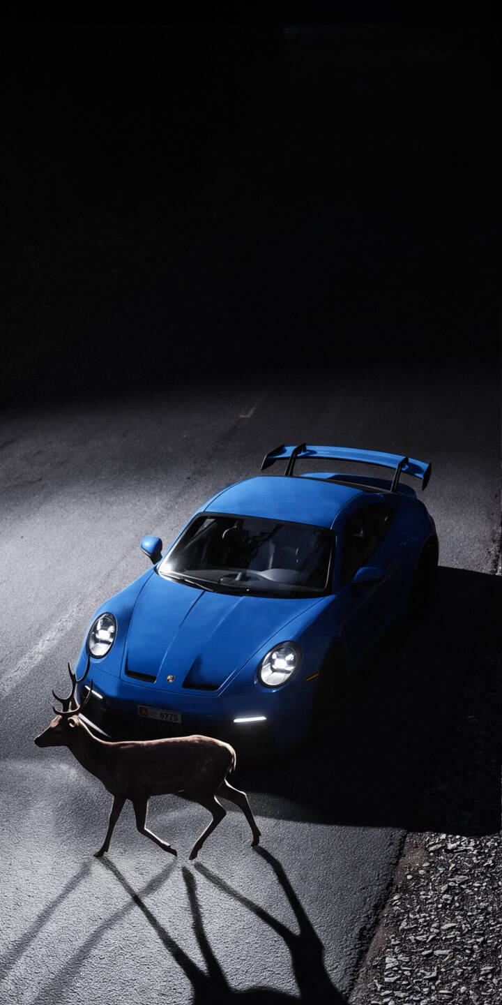 A majestic deer pauses under the piercing headlights of a brilliant blue Porsche GT3, creating a dramatic night scene in this stunning 4K wallpaper. This captivating wallpaper is perfect for iPhone users who appreciate the unexpected beauty of nature and automotive design. | night iphone porsche luxury deer wallpaper mobile blue car 4k wallpaper hd wallpaper wildlife automotive A majestic deer pauses under the piercing headlights of a brilliant blue Porsche GT3, creating a dramatic night scene in this stunning 4K wallpaper. This captivating wallpaper is perfect for iPhone users who appreciate the unexpected beauty of nature and automotive design.
