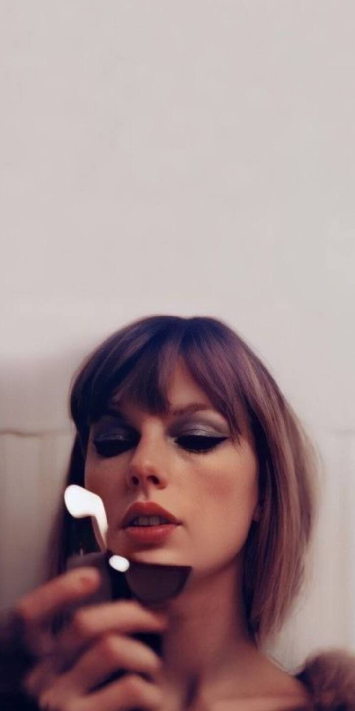 A soft, luminous flame glows from a lighter held by Taylor Swift, beautifully illuminating her smoky winged eyeliner and a captivating, direct gaze in this intimate 4K wallpaper. This stunning portrait wallpaper is perfect for any iPhone, capturing a moment of subtle allure. | artist A soft, luminous flame glows from a lighter held by Taylor Swift, beautifully illuminating her smoky winged eyeliner and a captivating, direct gaze in this intimate 4K wallpaper. This stunning portrait wallpaper is perfect for any iPhone, capturing a moment of subtle allure.