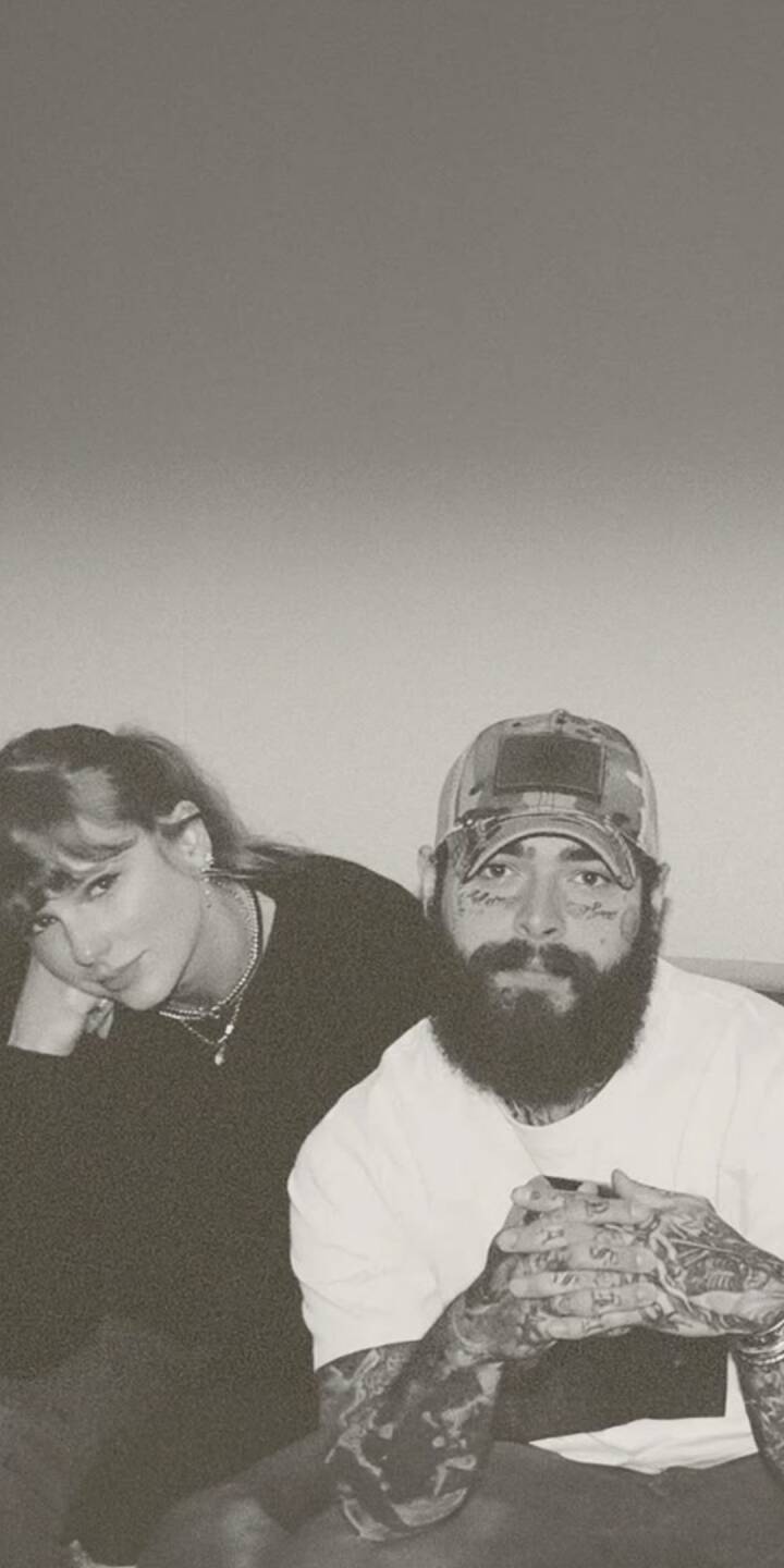 Taylor Swift subtly leans into frame beside a bearded Post Malone, both maintaining eye contact in this striking monochrome 4K wallpaper. This relaxed and intimate wallpaper captures the musical duo perfectly for your iPhone. | artist Taylor Swift subtly leans into frame beside a bearded Post Malone, both maintaining eye contact in this striking monochrome 4K wallpaper. This relaxed and intimate wallpaper captures the musical duo perfectly for your iPhone.