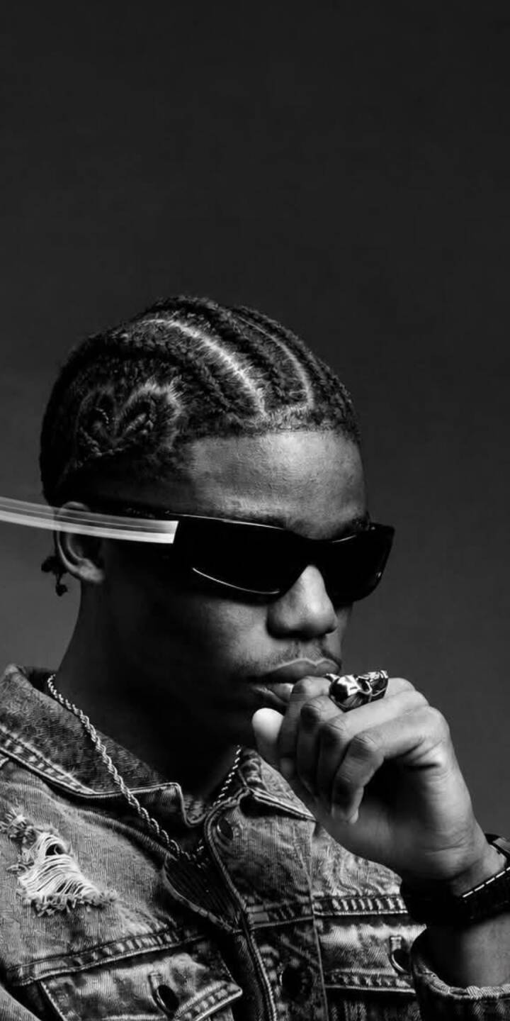 The stark black and white aesthetic highlights Wizkid's intricate braided hairstyle and dark sunglasses in this premium 4K wallpaper. This stunning wallpaper is perfect for personalizing your iPhone with an iconic, stylish look. | artist The stark black and white aesthetic highlights Wizkid's intricate braided hairstyle and dark sunglasses in this premium 4K wallpaper. This stunning wallpaper is perfect for personalizing your iPhone with an iconic, stylish look.