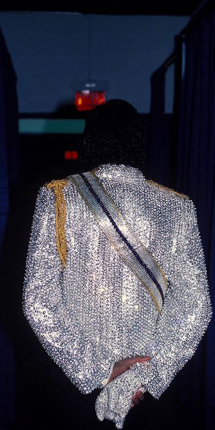 Michael Jackson's iconic silver jacket, shimmering with countless sequins, commands attention from behind in this captivating 4K wallpaper. This stunning wallpaper for iPhone perfectly captures the King of Pop's legendary style, complete with his signature gold shoulder braid and sequined glove. | artist Michael Jackson's iconic silver jacket, shimmering with countless sequins, commands attention from behind in this captivating 4K wallpaper. This stunning wallpaper for iPhone perfectly captures the King of Pop's legendary style, complete with his signature gold shoulder braid and sequined glove.