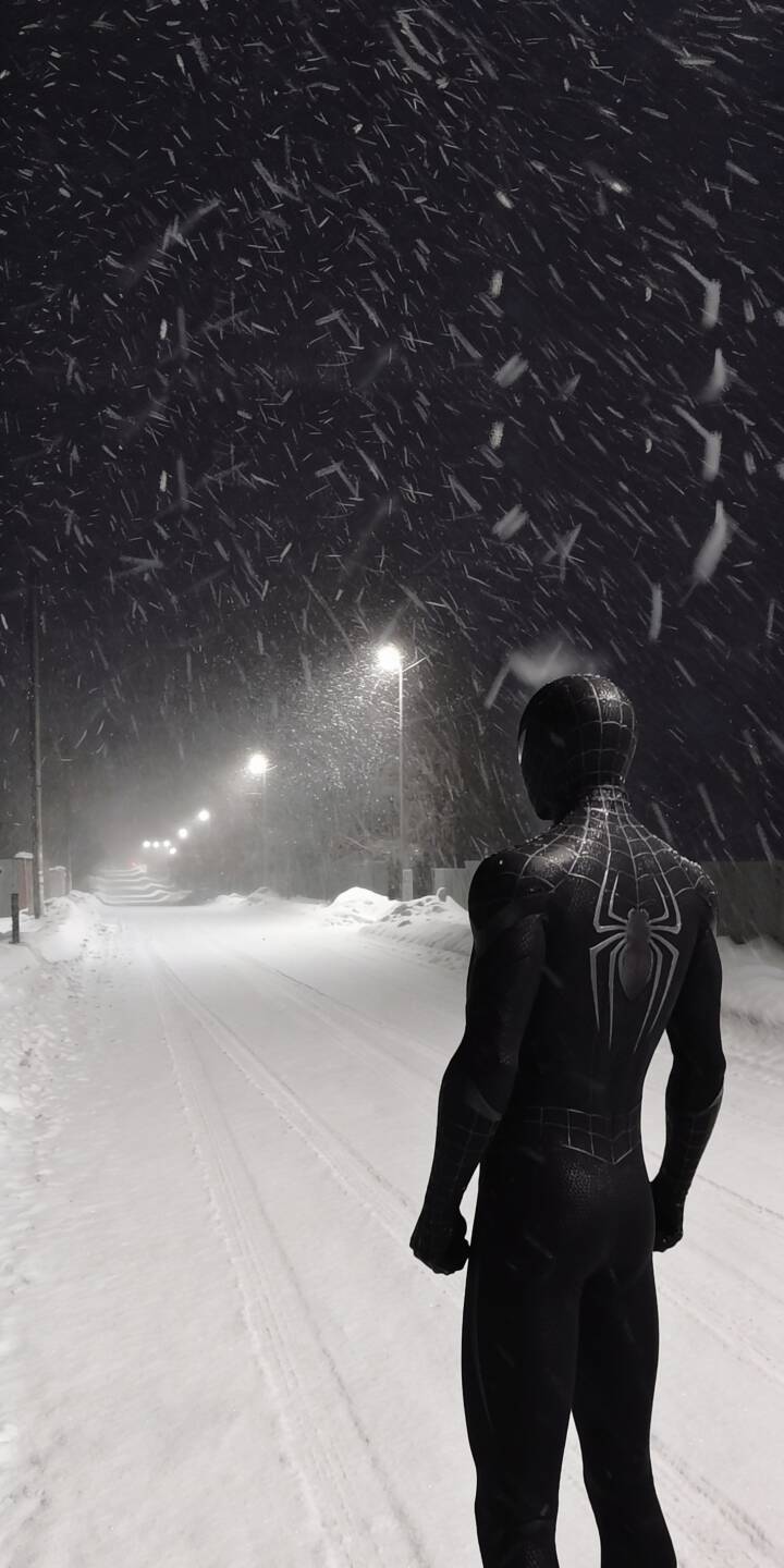 Amidst a silent, snowy night, Spider-Man's dark silhouette in his black symbiote suit stands facing a long, illuminated street, creating a moody 4K wallpaper perfect for iPhone. This unique wallpaper captures the hero in a reflective winter scene with glowing streetlights and falling snow. | dark night snow winter marvel iphone wallpaper mobile 4k wallpaper hd wallpaper symbiote suit spider-man Amidst a silent, snowy night, Spider-Man's dark silhouette in his black symbiote suit stands facing a long, illuminated street, creating a moody 4K wallpaper perfect for iPhone. This unique wallpaper captures the hero in a reflective winter scene with glowing streetlights and falling snow.