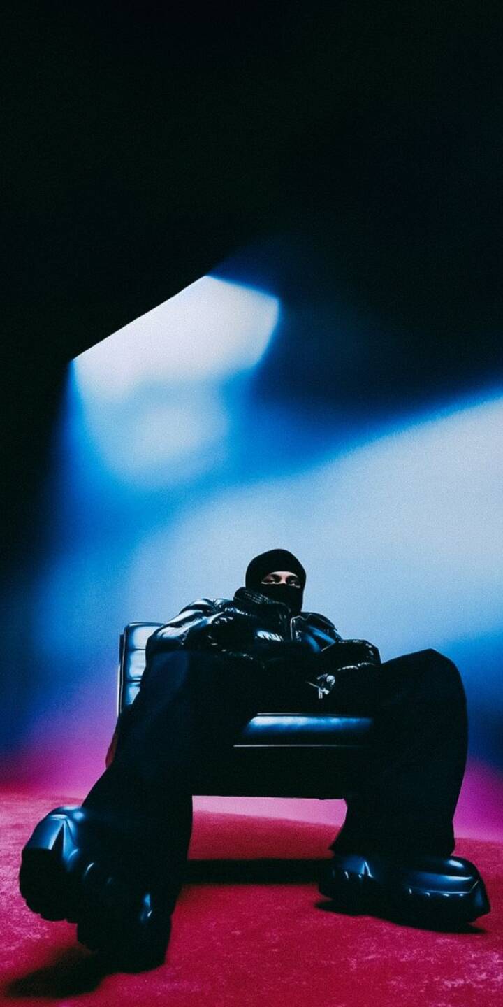 Intense blue and magenta lighting dramatically frames a mysterious figure in a black balaclava and puffer jacket, exuding a unique streetwear vibe. This striking 4K wallpaper, featuring distinctive chunky boots and a relaxed, powerful pose, is a perfect wallpaper for iPhone. | artist Intense blue and magenta lighting dramatically frames a mysterious figure in a black balaclava and puffer jacket, exuding a unique streetwear vibe. This striking 4K wallpaper, featuring distinctive chunky boots and a relaxed, powerful pose, is a perfect wallpaper for iPhone.
