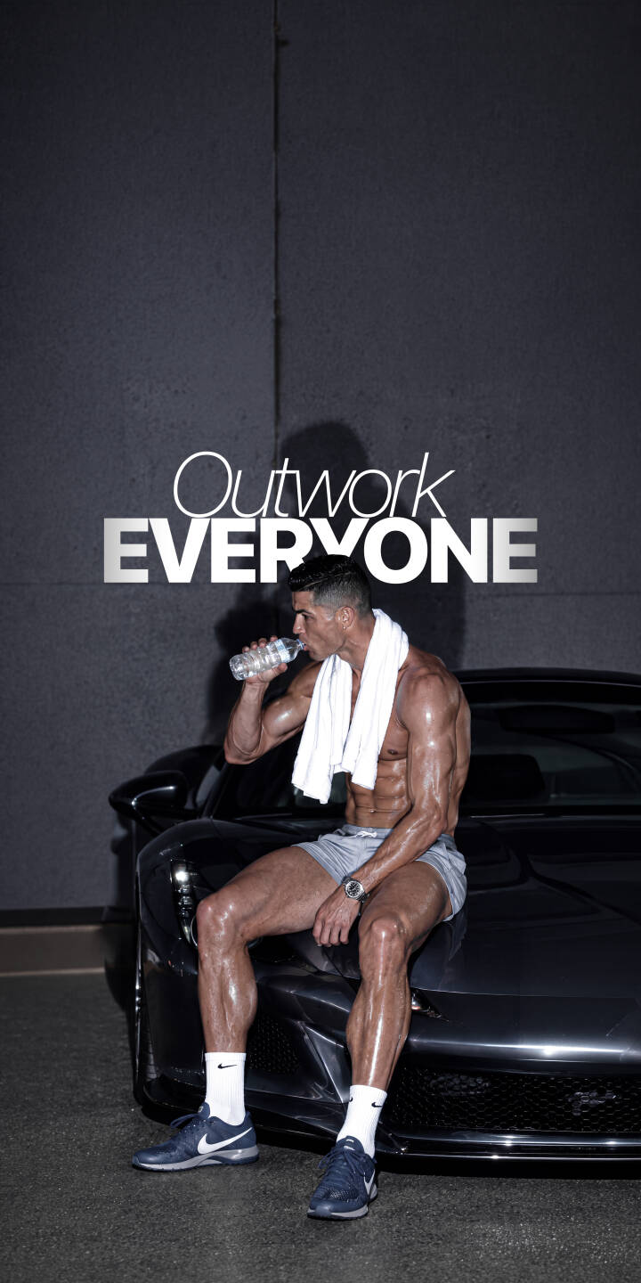 Cristiano Ronaldo's sweat-drenched, muscular physique gleams as he rehydrates by a sleek dark sports car in this motivational 4K wallpaper. The "Outwork EVERYONE" text above him drives home the inspiring message, making it a perfect iPhone wallpaper for your device. | sports car athlete motivational iphone wallpaper cr7 cristiano ronaldo mobile fitness 4k wallpaper hd wallpaper workout Cristiano Ronaldo's sweat-drenched, muscular physique gleams as he rehydrates by a sleek dark sports car in this motivational 4K wallpaper. The "Outwork EVERYONE" text above him drives home the inspiring message, making it a perfect iPhone wallpaper for your device.