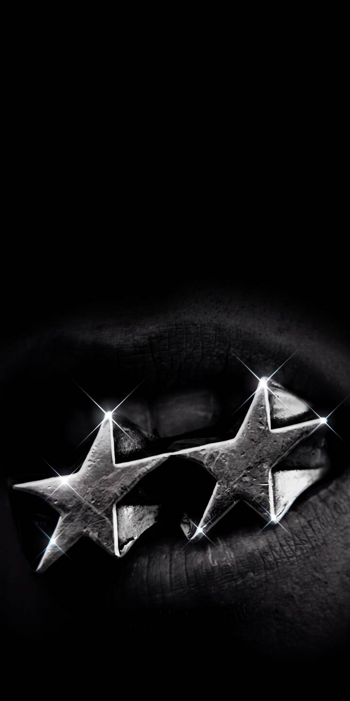 Shiny metallic star grillz gleam with stark brilliance against deeply shaded lips in this dramatic 4K wallpaper. This stunning black-and-white aesthetic wallpaper makes an edgy statement for your iPhone screen. | aesthetic dark iphone stars wallpaper lips grillz mobile 4k wallpaper hd wallpaper monochrome edgy Shiny metallic star grillz gleam with stark brilliance against deeply shaded lips in this dramatic 4K wallpaper. This stunning black-and-white aesthetic wallpaper makes an edgy statement for your iPhone screen.