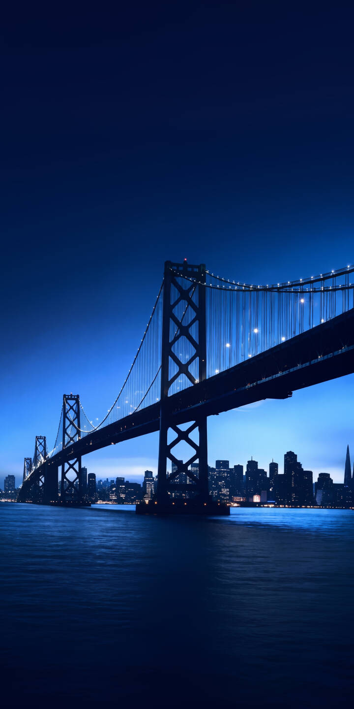 Electric blue hues dominate the tranquil waters around the iconic San Francisco Bay Bridge, which gleams with countless lights in this stunning 4K wallpaper. This serene night cityscape wallpaper is perfect for your iPhone screen. | blue night bay bridge architecture iphone san francisco wallpaper lights mobile 4k wallpaper hd wallpaper cityscape Electric blue hues dominate the tranquil waters around the iconic San Francisco Bay Bridge, which gleams with countless lights in this stunning 4K wallpaper. This serene night cityscape wallpaper is perfect for your iPhone screen.