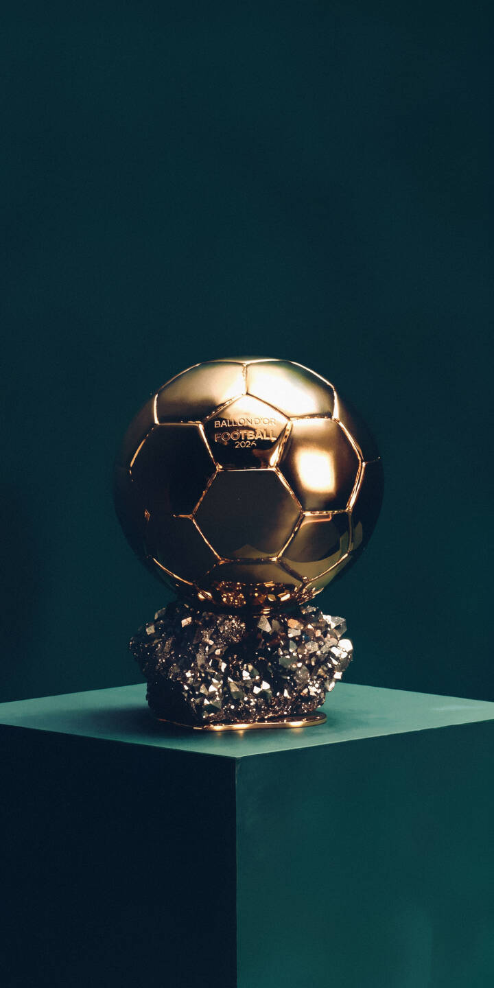 The iconic Ballon d'Or trophy, a shimmering golden football, rests majestically on a sparkling dark crystal base against a deep teal backdrop, offering an exquisite 4K wallpaper. This premium football award wallpaper for iPhone celebrates athletic excellence with sophisticated style. | iphone luxury wallpaper sport mobile elegant 4k wallpaper hd wallpaper ballon d'or football trophy golden award soccer award The iconic Ballon d'Or trophy, a shimmering golden football, rests majestically on a sparkling dark crystal base against a deep teal backdrop, offering an exquisite 4K wallpaper. This premium football award wallpaper for iPhone celebrates athletic excellence with sophisticated style.