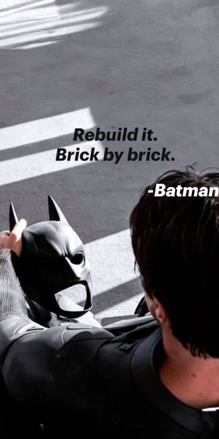 Powerful shadows stripe across Bruce Wayne as he holds his iconic Batman cowl, framed by the defiant quote "Rebuild it. Brick by brick." This compelling monochromatic 4K wallpaper is a perfect inspirational iPhone wallpaper for any fan. | artist Powerful shadows stripe across Bruce Wayne as he holds his iconic Batman cowl, framed by the defiant quote "Rebuild it. Brick by brick." This compelling monochromatic 4K wallpaper is a perfect inspirational iPhone wallpaper for any fan.