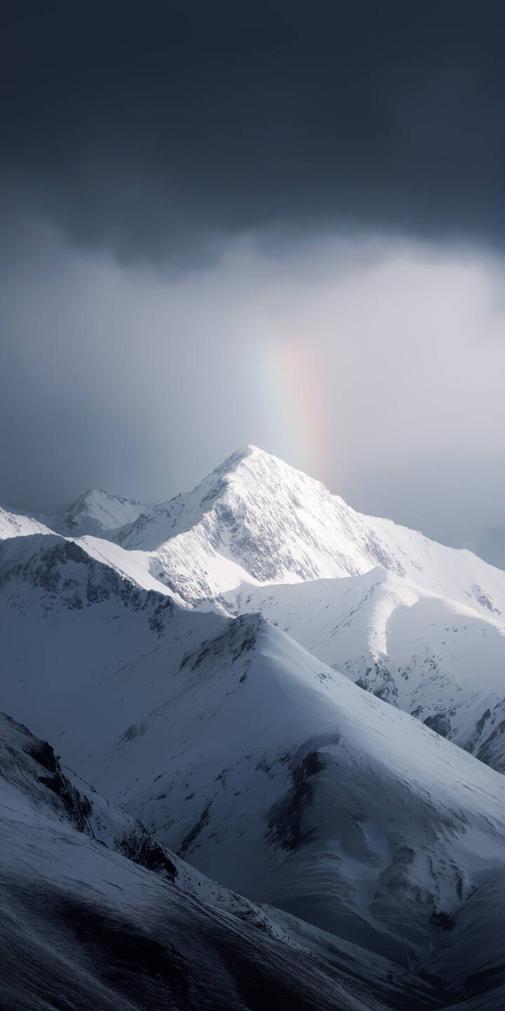 A faint, ethereal rainbow arches over pristine snow-covered mountains, casting dramatic lighting against the dark, moody clouds in this breathtaking 4K wallpaper. This stunning natural landscape is an ideal wallpaper for iPhone users seeking a serene yet powerful scene. | landscape snow winter rainbow iphone nature mountains wallpaper mobile 4k wallpaper hd wallpaper scenic A faint, ethereal rainbow arches over pristine snow-covered mountains, casting dramatic lighting against the dark, moody clouds in this breathtaking 4K wallpaper. This stunning natural landscape is an ideal wallpaper for iPhone users seeking a serene yet powerful scene.